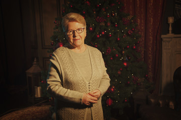 an elderly woman in front of the tree