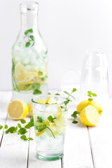 Citrus lemonade in a glass cup on a white wooden table..