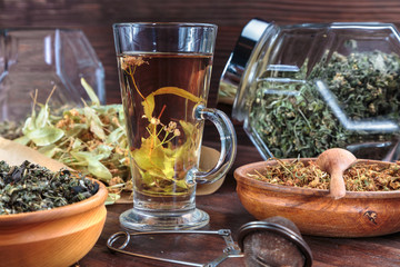 linden tea on a background of dried lime flowers, lemon balm and St. John's wort