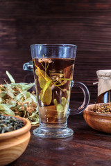 linden tea on a background of dried lime flowers, lemon balm and St. John's wort