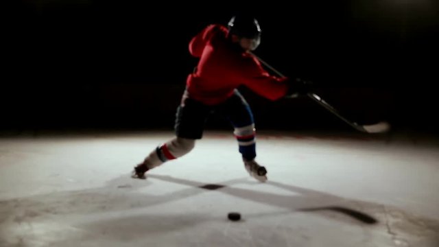 Professional hockey player produces a shot on goal at ice arena.