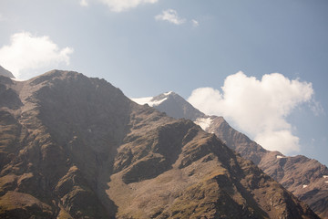 cima di mintagna con neve e cielo con nuvole bianche