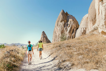 Group of Friends travelling among Cappadocia fairy chimneys at summer