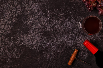 Wine, glasses, grapes and corkscrew over stone background.