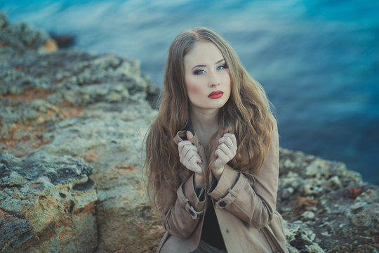 Seductive Sexy Lady Girl With Romantic Pout Red Lips And Pinky Cheeks Wearing Stylish Jacket Dress And Shorts With Autumn Boots Posing At Rocky Beach Sea Side With Make Up On Face I Romantic Episode