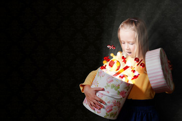 Bondes Mädchen for der schwarzen Tapete öffnet ein Geschenk mit Prozentzeichen