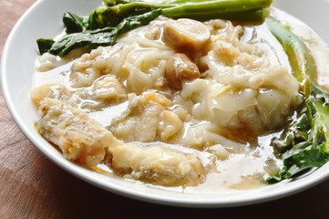 stir fried rice noodle with bass fish and Chinese kale in gravy sauce on plate