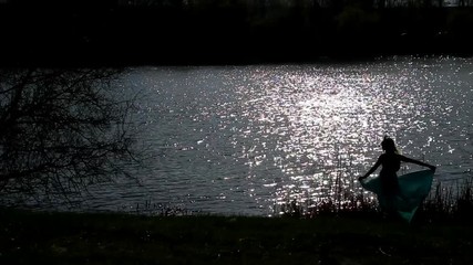 general outline silhouette of a dancing girl against the background of water and sky
