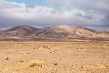 Dry out desert in Fuerteventura with mountains behind 