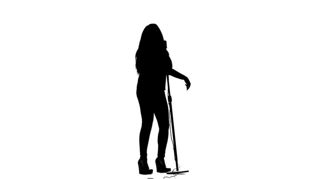 Singer performs songs in a retro microphone sexually moving. White background. Silhouette