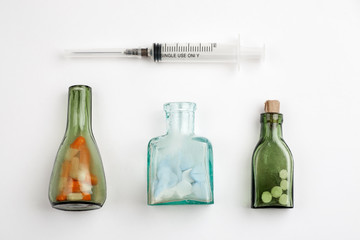 Different medications and pills with vintage pharmacy bottles on a white background