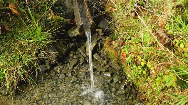 mountain spring. view from above on a wooden chute