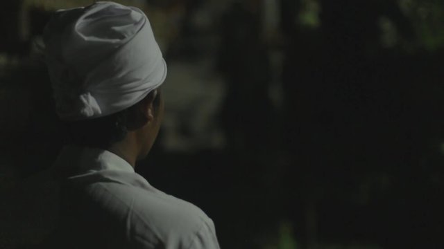 Balinese man lights incense and does ceremonial prayers.