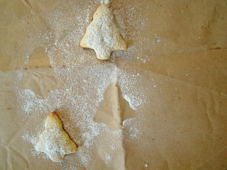 Christmas cookies on paper and powered sugar.
