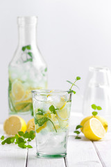 Lemonade in a glass cup on a white wooden table..