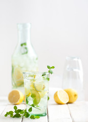 Lemonade lemonade in a glass cup on a white wooden table..