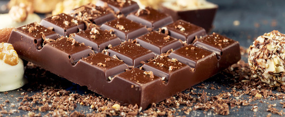 Bar of dark chocolate and candies with copy space