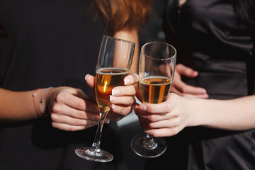 Beautiful girls in evening dresses with glasses of champagne to celebrate the New year