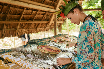 Female tourist selects spices on the market - obrazy, fototapety, plakaty