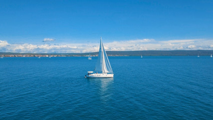 Aerial view of yacht sailing near beautiful Islands. Beautiful clouds in the background. Luxury yacht in the sea.