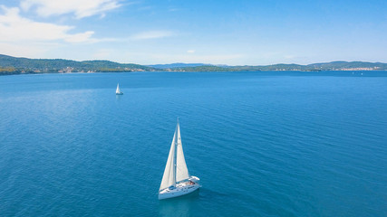 Aerial view of yacht sailing near beautiful Islands. Beautiful clouds in the background. Luxury...