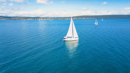 Aerial view of yacht sailing near beautiful Islands. Beautiful clouds in the background. Luxury yacht in the sea.
