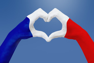 Hands flag of France, shape a heart. Concept of country symbol, on blue sky.
