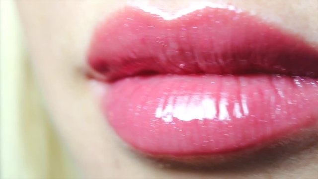 Female open smiling mouth with sexy lips pink gloss and tongue. Closeup