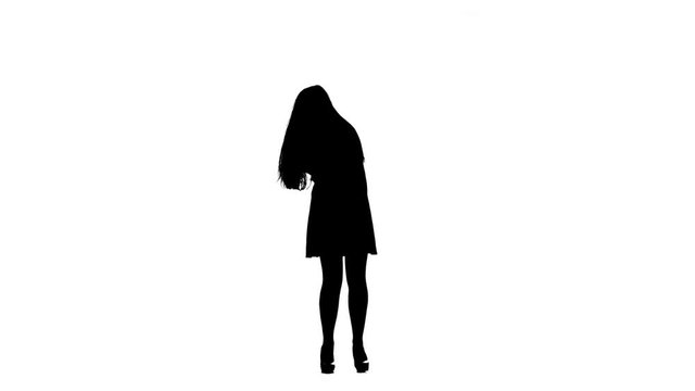 Actress in a retro microphone sings a rock song, her hair flies to the beat of the music. White background. Silhouette. Slow motion