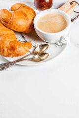 Homemade continental breakfast, coffee croissants. jam on white marble table, copy space