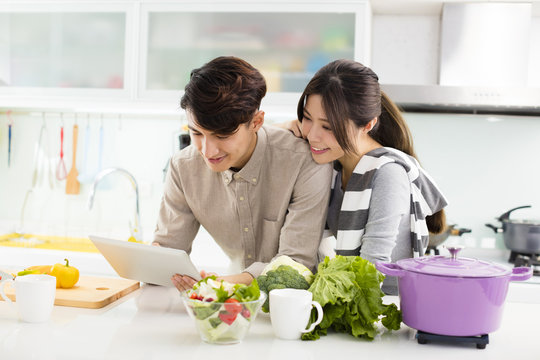 young asian couple cooking in kitchen