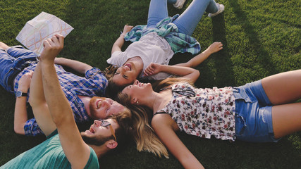 Young tourists resting on grass while traveling