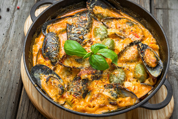 mussels with cheese sauce, in a frying pan