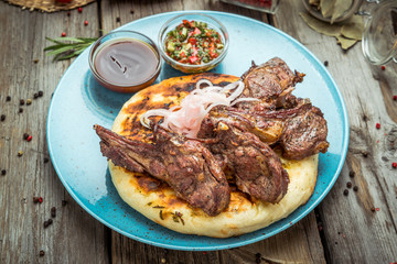 two pieces of of grilled pork with herbs on a paper