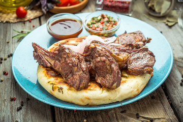 two pieces of of grilled pork with herbs on a paper