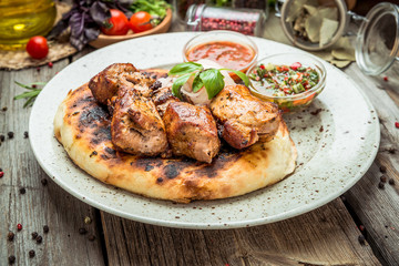 two pieces of of grilled pork with herbs on a paper