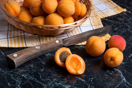 Fresh organic apricots in basket. Group of harvested apricots in basket with vintage knife..
