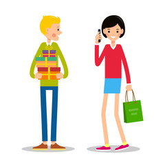 Young man is standing and holding several gift boxes. Young girl is standing next to shopping bag and talking on phone