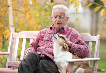 Old man with dog on bench in park