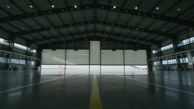 Big modern aircraft hangar with big gate at sunny summer day. Gate of the aircraft hangar
