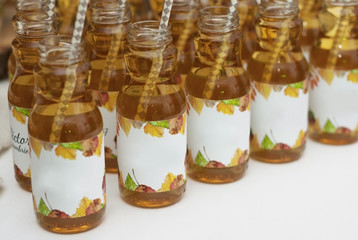 Apple Juice in Glass Bottles on white table with Straw. Autumn Concept.