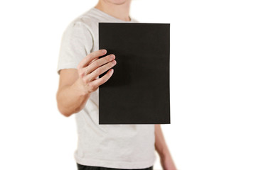 Man holding black A4 paper vertically. Leaflet presentation. Pamphlet hold hands. Man show clear offset paper. Sheet template. Booklet design sheet display read first person