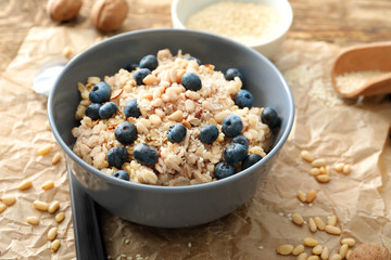 Tasty oatmeal with berries in bowl on table