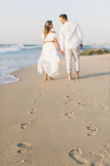 A loving couple is walking on the beach