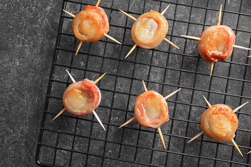 Baking grid with bacon wrapped scallops on table