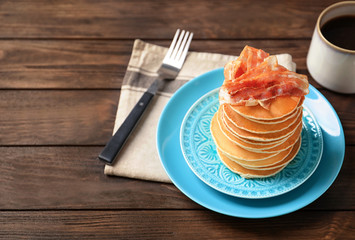 Tasty pancakes with bacon on plate