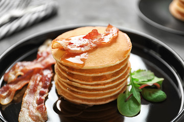 Tasty pancakes with bacon on plate