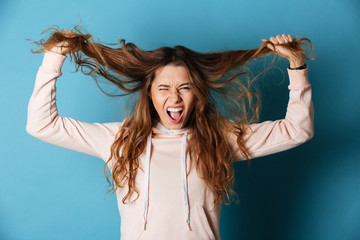 Young angry screaming woman standing isolated