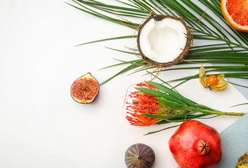 Composition with tropical leaves and exotic fruits on white background