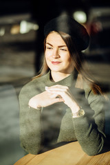 Close up portrait of charming brunette woman while waiting order in cafe. The photo was taken...